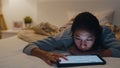 Freelance Asia women casual wear using laptop hard work on bed in bedroom at house night. Working from home, remotely work, self Royalty Free Stock Photo