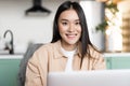 Freelance asian girl sitting at home and working with laptop, smiling at camera. Young woman using computer, studying Royalty Free Stock Photo