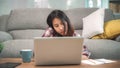 Freelance Asian woman working at home, business female working on laptop and using mobile phone talking with customer on sofa in Royalty Free Stock Photo