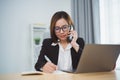 Freelance business woman calling on mobile smartphone while working with laptop, businesswoman mobile phone to calling with