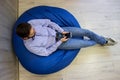 Freelance businessman. Young handsome man and using smart phone while sitting on the blue beanbag Royalty Free Stock Photo