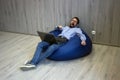 Freelance businessman. Young handsome man sleep with laptop sitting on the blue beanbag chair Royalty Free Stock Photo
