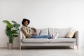 Freelance Career. Relaxed Black Man Working With Laptop While Sitting On Sofa