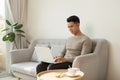 Freelance Career. Smiling Man Working On Laptop Computer Sitting On Sofa At Home Royalty Free Stock Photo