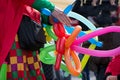 A freelance clown creating balloon animals and different shapes at outdoor festival in city center. Royalty Free Stock Photo