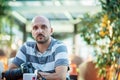 Freelance concept. Professional photographer. Young bearded man using laptop while sitting on summer terrace.