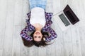 Freelance concept. Young successful woman having break while lying on the floor with laptop, dreaming and smiling Royalty Free Stock Photo