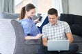 Freelance Couple Working From Home Looking At Laptop Together