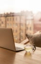 Freelance Desk with open laptop, cup of green tea and glasses on table. Cafe or coworking space. Concept of digital nomads, home