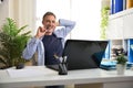 Freelance entrepreneur smiling biting a pen in his home office