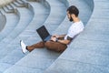 Remote worker typing on computer. Freelance guy with laptop is working on steps. Busy Royalty Free Stock Photo