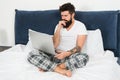 Freelance job. Stay in bed and keep working. Freelance benefits. Man surfing internet or working online. Hipster bearded Royalty Free Stock Photo