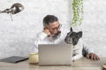 Freelance man working from home with his dog sitting in the office. Man using a laptop at home with a cute dog Royalty Free Stock Photo