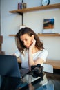 Freelance photographer woman with camera at home office editing photos on laptop Royalty Free Stock Photo