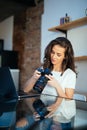 Freelance photographer woman with camera at home office editing photos on laptop Royalty Free Stock Photo