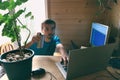 Freelance programmer drinks and write code, work from home in quarantine, lifestyle workspace and workplace, side view