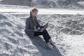 Freelance and remote work.business woman in stylish business suit with laptop sitting in desert sand. Female student