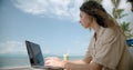 Freelance woman works on the beach at the cafe. 6k footage Red Komodo