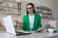 Freelance. Work at home. Confused woman sitting at table with laptop, talking on video call Royalty Free Stock Photo