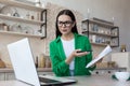 Freelance. Work at home. Confused woman sitting at table with laptop, talking on video call Royalty Free Stock Photo