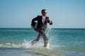 Freelance work, online business. Summer business. Businessman in suit hold laptop and run on sea. Funny business man in Royalty Free Stock Photo