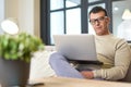 Freelance worker. Portrait of latin middle aged business man with eyeglasses working at home on some project, sitting on