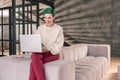 Freelance writer working on her laptop sitting on sofa at home