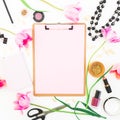 Freelancer or blogger workspace with clipboard, notebook, cosmetics, tulip flowers and accessories on white background. Flat lay, Royalty Free Stock Photo