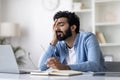 Freelancer Burnout. Tired Indian Man Feeling Sleepy At Workplace In Home Office Royalty Free Stock Photo