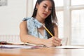 Freelancer business woman holding pen while analysing business chart in cafe