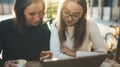 Freelancer communicate on project in cafe outdoor, girls using digital tablet. Friends talking in sun Barcelona. Working business Royalty Free Stock Photo