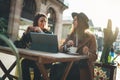 Freelancer communicate using digital laptop. Young girls drink coffee in sun city. Working business process concept Royalty Free Stock Photo