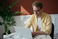 Freelancer copywriter working from home. Pensive man using laptop computer typing on keyboard, watching online training courses. P