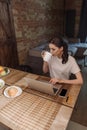 Freelancer drinking coffee near laptop, smartphone