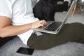 Freelancer guy with laptop and dog is working at home in quarantine to coronavirus infection Royalty Free Stock Photo