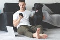 Freelancer guy with laptop and dog is working at home in quarantine to coronavirus infection Royalty Free Stock Photo