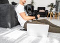 freelancer guy sitting at home working with a dog in an embrace, black labrador.