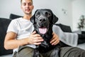 Freelancer guy sitting at home working in laptop and with dog in Royalty Free Stock Photo