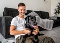 Freelancer guy sitting at home working in laptop and with dog in Royalty Free Stock Photo