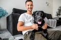 Freelancer guy sitting at home working in laptop and with dog in Royalty Free Stock Photo