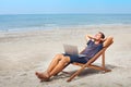 Freelancer with laptop on the beach, successful happy business man relaxing Royalty Free Stock Photo