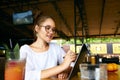 Freelancer mixed race woman hand pointing with stylus on convertible laptop screen in tent mode. Asian caucasian girl