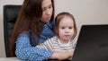 Freelancer Mom and child work on the computer remotely at home. Mother works with a laptop and plays with her little Royalty Free Stock Photo