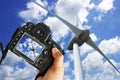 Freelancer photographer with DSLR camera taking picture of wind turbine in a sunny day Royalty Free Stock Photo