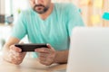 Freelancer playing mobile video game on smartphone in home office Royalty Free Stock Photo