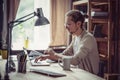 Freelancer sitting at table typling on laptop.