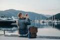 Freelancer taking photo and working on laptop on the shore near Royalty Free Stock Photo