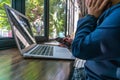 Woman using cellphone and working on laptop at beautiful workplace