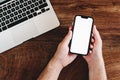 Freelancer using mobile phone with blank white mockup screen at office desk Royalty Free Stock Photo