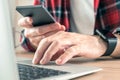 Freelancer using smartphone and laptop computer in home office Royalty Free Stock Photo